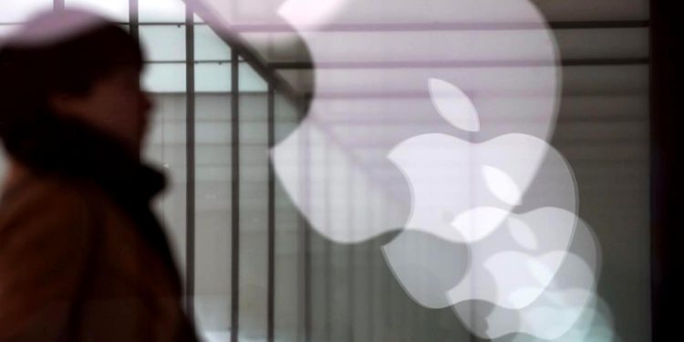 Apple company logos are reflected on the glass window outside an Apple store in Shanghai, China January 3, 2019. REUTERS