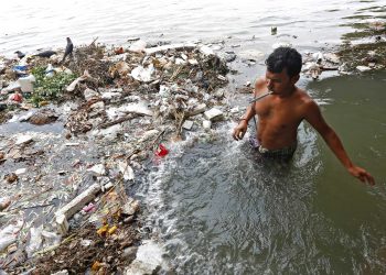 A man brushes his teeth as he stands in the polluted water of Ganges river in Kolkata, India. (REUTERS)