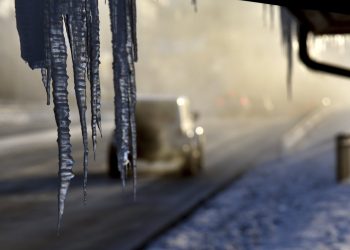 Icicles hang from the Harrington Inn in Geneva, Ill., as commuters pass by Thursday, Jan. 31, 2019. The cold weather system holding much of the Midwest in a historic deep freeze sent temperatures plunging to a record low in northern Illinois on Thursday. (AP)
