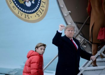 US President Donald Trump says he would not encouragae his son Barron, seen here boarding Air Force One with his father, to play American football (AFP)