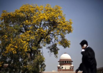 A lawyer speaks on his mobile phone as he walks past the Supreme Court in New Delhi April 1, 2013. (REUTERS)