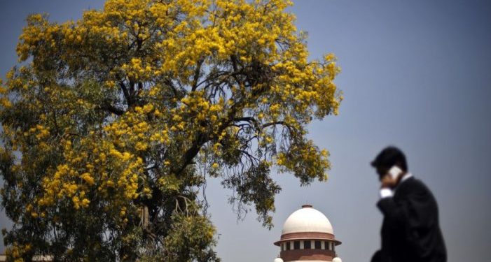 A lawyer speaks on his mobile phone as he walks past the Supreme Court in New Delhi April 1, 2013. (REUTERS)