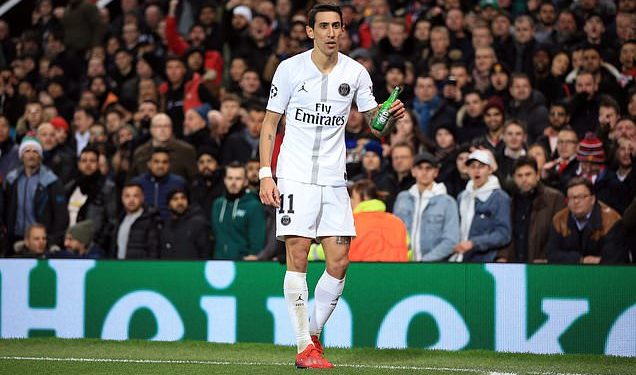 Angel di Maria of PSG holds the bottle thrown at him from the crowd