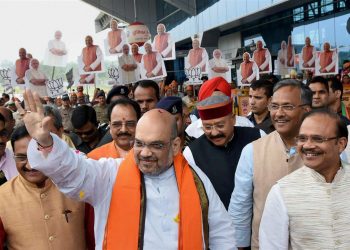 Dehradun: BJP President Amit Shah waves at the party workers on his arrival in Dehradun Tuesday. (PTI)