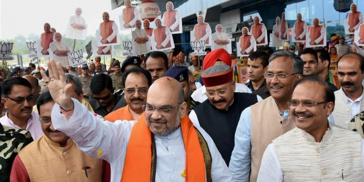 Dehradun: BJP President Amit Shah waves at the party workers on his arrival in Dehradun Tuesday. (PTI)
