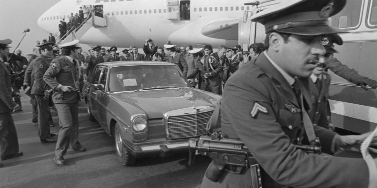 FILE - In this Feb. 1, 1979 file photo, Ayatollah Ruhollah Khomeini has a heavy escort as he enters car to leave the airport in Tehran, Iran. Forty years ago, Iran's ruling shah left his nation for the last time and an Islamic Revolution overthrew the vestiges of his caretaker government. The effects of the 1979 revolution, including the takeover of the U.S. Embassy in Tehran and ensuing hostage crisis, reverberate through decades of tense relations between Iran and America. (AP)