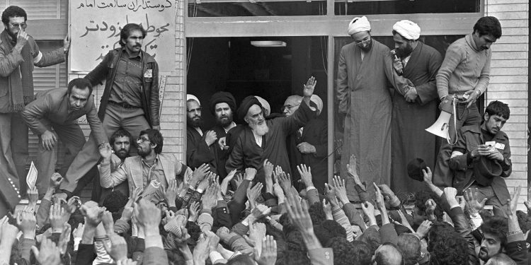 FILE - In this Feb. 1, 1979 file photo, Ayatollah Ruhollah Khomeini, center, waves to followers as he appears on the balcony of his headquarters in Tehran, Iran. Forty years ago, Iran's ruling shah left his nation for the last time and an Islamic Revolution overthrew the vestiges of his caretaker government. The effects of the 1979 revolution, including the takeover of the U.S. Embassy in Tehran and ensuing hostage crisis, reverberate through decades of tense relations between Iran and America. (AP)