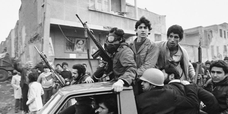 FILE - In this Feb. 12, 1979 file photo, armed rebels, one wearing a gas mask, ride in a truck near the headquarters of Ayatollah Khomeini in Tehran, Iran. Forty years ago, Iran's ruling shah left his nation for the last time and an Islamic Revolution overthrew the vestiges of his caretaker government. The effects of the 1979 revolution, including the takeover of the U.S. Embassy in Tehran and ensuing hostage crisis, reverberate through decades of tense relations between Iran and America. (AP)