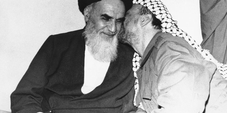 FILE - In this Feb. 18, 1979 file photo, Palestinian Liberation Organization leader Yasser Arafat, right, kisses Ayatollah Ruhollah Khomeini, left, during a meeting in Tehran, Iran. Forty years ago, Iran's ruling shah left his nation for the last time and an Islamic Revolution overthrew the vestiges of his caretaker government. The effects of the 1979 revolution, including the takeover of the U.S. Embassy in Tehran and ensuing hostage crisis, reverberate through decades of tense relations between Iran and America. (AP)