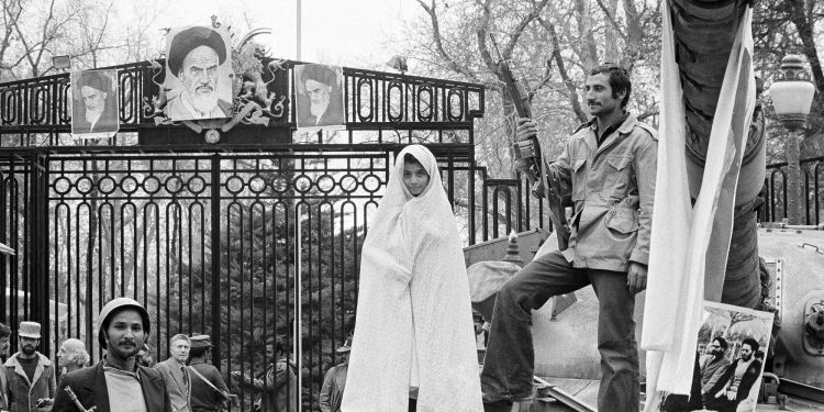 FILE - In this undated photo from 1979, a small Iranian girl stands on a captured tank at the entrance to Niavaran Palace where Shah Mohammad Reza Pahlavi once lived in Tehran, Iran. Forty years ago, Iran's ruling shah left his nation for the last time and an Islamic Revolution overthrew the vestiges of his caretaker government. The effects of the 1979 revolution, including the takeover of the U.S. Embassy in Tehran and ensuing hostage crisis, reverberate through decades of tense relations between Iran and America. (AP)