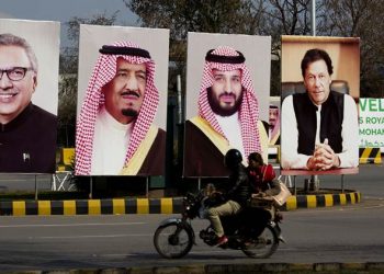 Pakistani riders drive past portraits of Pakistani and Saudi leaders display on the occasion of the visit by Saudi Arabia's Crown Prince to Pakistan, in Islamabad, Pakistan, Friday, Feb. 15, 2019. Pakistan said Wednesday that Crown Prince Mohammed bin Salman will arrive in Islamabad later this week on an official visit that is expected to include the signing of agreements for billions of dollars of investment in Pakistan. (AP Photo/B.K. Bangash)