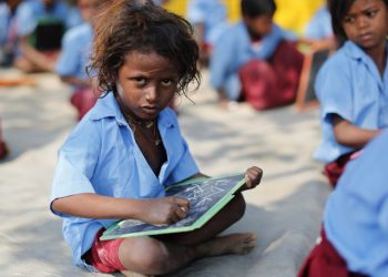 A child whose parents work in a brick kiln attends a class in an open air school at Krishnadevpur village, north of Kolkata, February 11, 2014. REUTERS/Ahmad Masood (INDIA - Tags: EDUCATION SOCIETY) - RTX18LLP