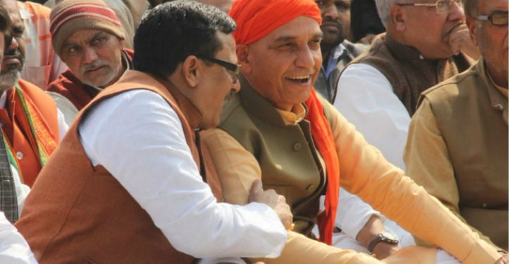 Union Minister Satyapal Singh (R) wears a big smile on his face as he listens to a party worker during Ajay Kumar’s cremation in Meerut, Tuesday