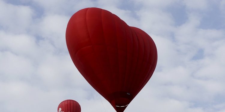 A heart shaped hot-air balloon (R) flies in the sky during the Love Cup 2016 event, ahead of Valentine’s Day, in Jekabpils, Lativa, February 13, 2016 (REUTERS)