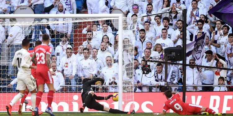 Home fans look closely as Real Madrid custodian Thibaut Courtois fails to hold the ball from a Cristian Portu header for the second Girona goal at Madrid, Sunday