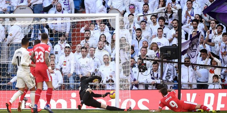 Home fans look closely as Real Madrid custodian Thibaut Courtois fails to hold the ball from a Cristian Portu header for the second Girona goal at Madrid, Sunday