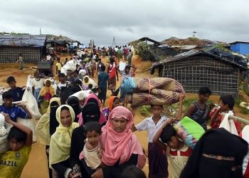 Rohingya  refugees  exhausted  streaming  off  boats  arriving  on  the  beach  (Shamlapur  village,  Bangladesh,  2017-09-06
