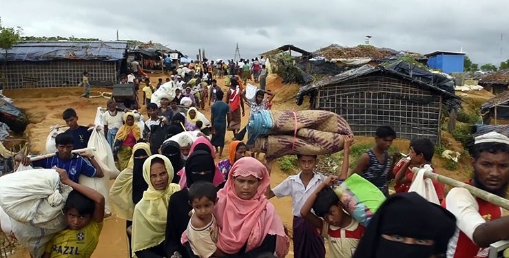 Rohingya  refugees  exhausted  streaming  off  boats  arriving  on  the  beach  (Shamlapur  village,  Bangladesh,  2017-09-06