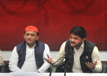 Akhilesh Yadav (L) listens as Hardik Patel talks to reporters in Lucknow, Thursday