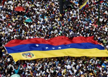 Opposition activists display a Venezuelan flag as they pour to the streets to back Venezuelan opposition leader Juan Guaido's calls for early elections, in Caracas February 2, 2019 (AFP)