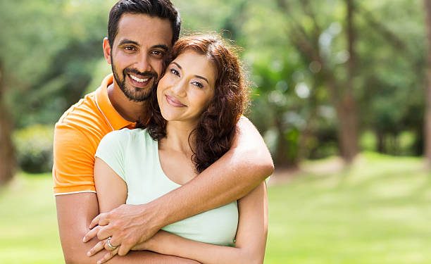 lovely young indian couple hugging outdoors