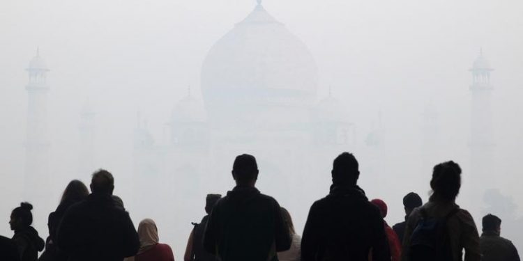 Visitors look toward the Taj Mahal through morning air pollution in Agra, India, January 12, 2019. (REUTERS/Andrew Kelly)