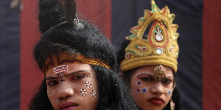 Children, dressed up as a Hindu God and Goddess, look on as they beg for alms during "Kumbh Mela", or the Pitcher Festival, in Prayagraj, previously known as Allahabad, India, January 14, 2019. (REUTERS/Anushree Fadnavis)