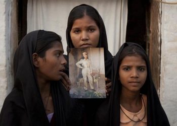 Bibi's daughters with an image of their mother outside their residence in Sheikhupura in Punjab province