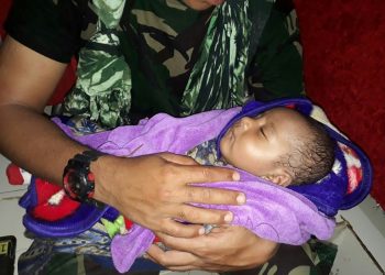 The baby was plucked from debris inside a house where his mother and siblings were found dead (AFP)