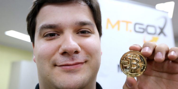 Mark Karpeles, chief executive officer of Tibanne Co., poses for a photograph with a bitcoin in the office operating the Mt.Gox K.K. bitcoin exchange in Tokyo, Japan, on Thursday, April 25, 2013. Bitcoin digital currency, which carries the unofficial ticker symbol of BTC, was unveiled in 2009 by an unidentified programmer, or group of programmers, under the name of Satoshi Nakamoto. Supply is capped at 21 million Bitcoins and managed by a software algorithm embedded into the digital currency?s design, rather than a monetary authority such as a central bank. (Photographer: Tomohiro Ohsumi/Bloomberg via Getty Images/AFP)