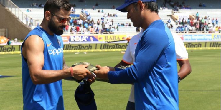 MS Dhoni hands over the camouflage military cap to Virat Kohli prior to the start of the third ODI against Australia at Ranchi, Friday