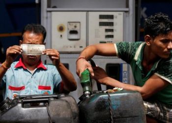 Man fills gallon with disel as the staff verifies currency notes at a filling station in New Delhi. (REUTERS)