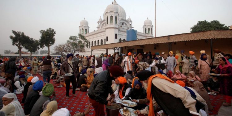 A man serves food to Sikhs from India outside the shrine of Guru Nanak Dev Ji, founder of Sikhism, during the groundbreaking ceremony of the Kartarpur border corridor, which will officially open next year, in Kartarpur, Pakistan November 28, 2018. REUTERS/Mohsin Raza/Files