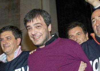 Italian policemen celebrate as they escort Antonio Iovine (centre), one of the most powerful leaders of the Camorra organised crime group, on his arrest after 14 years on the run, yesterday in Naples. (AFP)
