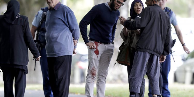 People stand across the road from a mosque in central Christchurch, New Zealand, Friday, March 15, 2019. A witness says a number of people have been killed in a mass shooting at a mosque in the New Zealand city of Christchurch; police urge people to stay indoors.(AP Photo/Mark Baker)