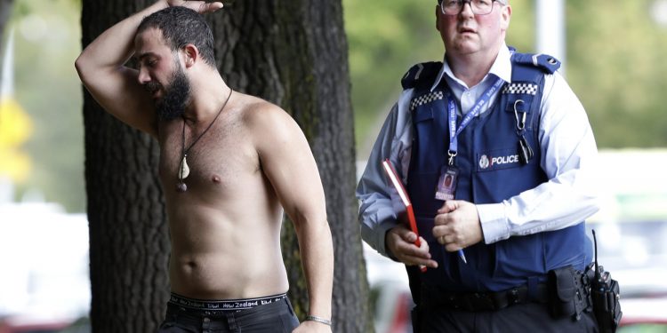A police officer escorts a man away from a mosque in central Christchurch, New Zealand, Friday, March 15, 2019. Multiple people were killed in mass shootings at two mosques full of people attending Friday prayers, as New Zealand police warned people to stay indoors as they tried to determine if more than one gunman was involved. (AP Photo/Mark Baker)