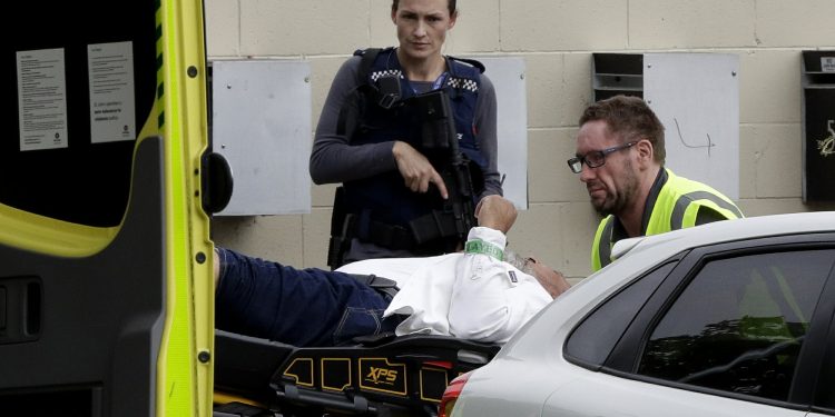 An armed police officer watches as a man is taken by ambulance staff from a mosque in central Christchurch, New Zealand, Friday, March 15, 2019. Multiple people were killed in mass shootings at two mosques full of people attending Friday prayers, as New Zealand police warned people to stay indoors as they tried to determine if more than one gunman was involved. (AP Photo/Mark Baker)