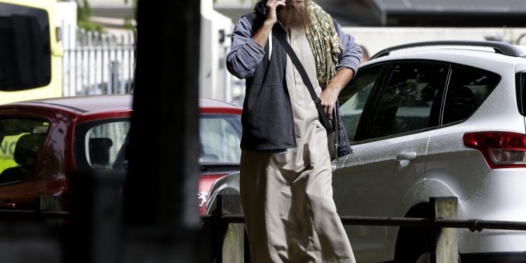 A man talks on his mobile phone across the road from a mosque in central Christchurch, New Zealand, Friday, March 15, 2019. A witness says a number of people have been killed in a mass shooting at a mosque in the New Zealand city of Christchurch; police urge people to stay indoors. (AP Photo/Mark Baker)