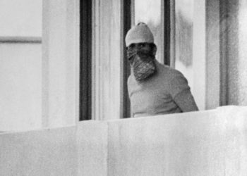 A member of the Palestinian terrorist group Black September appears on the balcony of the Israeli house at the Munich Olympic village September 5, 1972. (Image: AP)