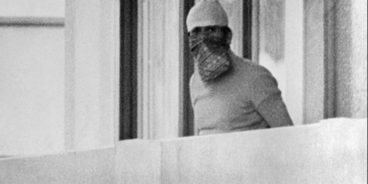 A member of the Palestinian terrorist group Black September appears on the balcony of the Israeli house at the Munich Olympic village September 5, 1972. (Image: AP)