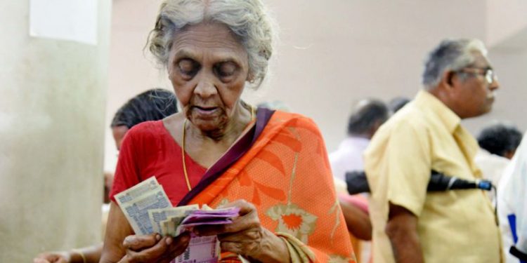 An aged woman counts her pension amount after withdrawing cash at the treasury office in Thiruvananthapuram Thursday 21 June 2018 [Representational Image] (PTI)