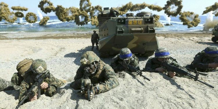 In this March 12, 2016, file photo, Marines of the U.S., left, and South Korea, wearing blue headbands on their helmets, take positions after landing on a beach during the joint military combined amphibious exercise, called Ssangyong, part of the Key Resolve and Foal Eagle military exercises, in Pohang, South Korea. South Korea and the U.S. say they've decided to end their springtime military drills to back diplomacy with North Korea. (AP)