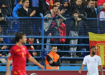 A home fan (C) makes an abusive comment to Raheem Sterling (R) during England’s match at Montenegro