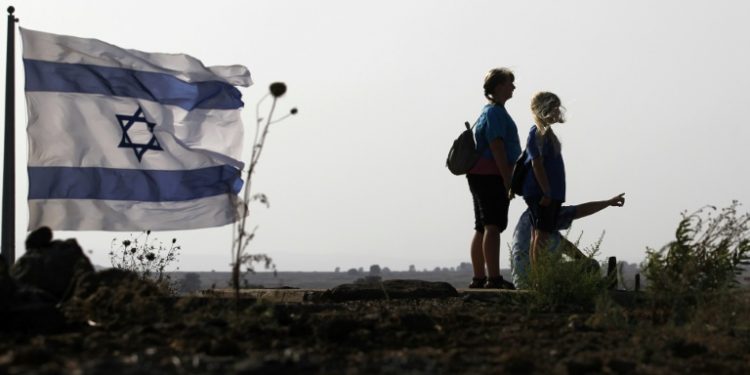 Israelis in the annexed Golan Heights watch the progress of fighting on the other side of the armistice line in July 2018 as pro-Damascus forces seize the upper hand over rebels (AFP)