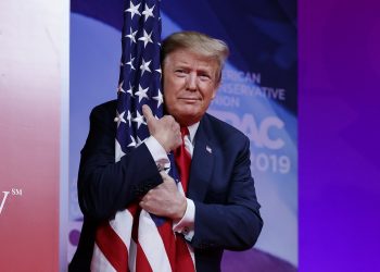 President Donald Trump hugs the American flag as he arrives to speak at Conservative Political Action Conference, CPAC 2019, in Oxon Hill, Md., Saturday, March 2, 2019. (AP)