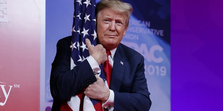 President Donald Trump hugs the American flag as he arrives to speak at Conservative Political Action Conference, CPAC 2019, in Oxon Hill, Md., Saturday, March 2, 2019. (AP)