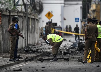 Sri Lankan security personnel inspect the debris of a van after it explodes on Monday near St. Anthony's Shrine in Colombo. Nearly 300 people died and more than 500 others were wounded after Sunday's attacks on churches and hotels.