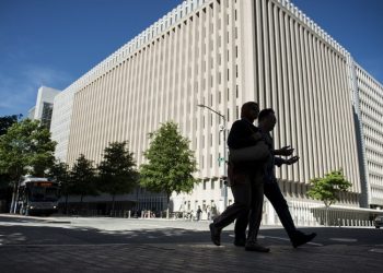 People walk past the World Bank Group's headquarters May 3, 2013 in Washington, DC. (BRENDAN SMIALOWSKI/AFP/Getty Images)