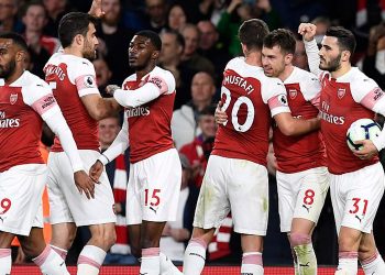 Arsenal players congratulate Aaron Ramsey (8) after he scored the first goal for his team, Monday