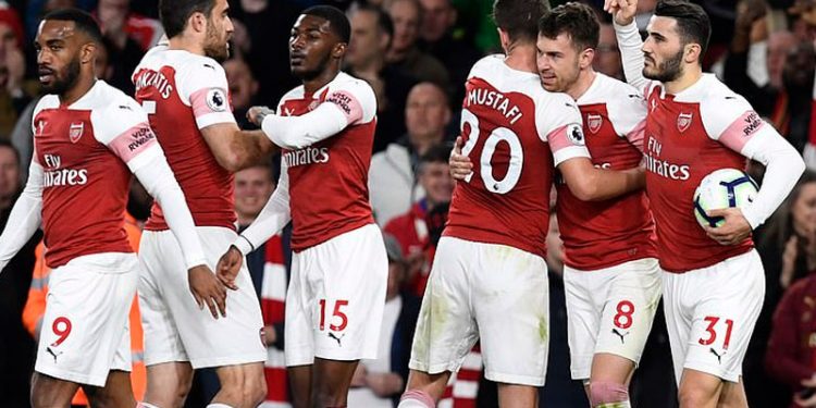 Arsenal players congratulate Aaron Ramsey (8) after he scored the first goal for his team, Monday